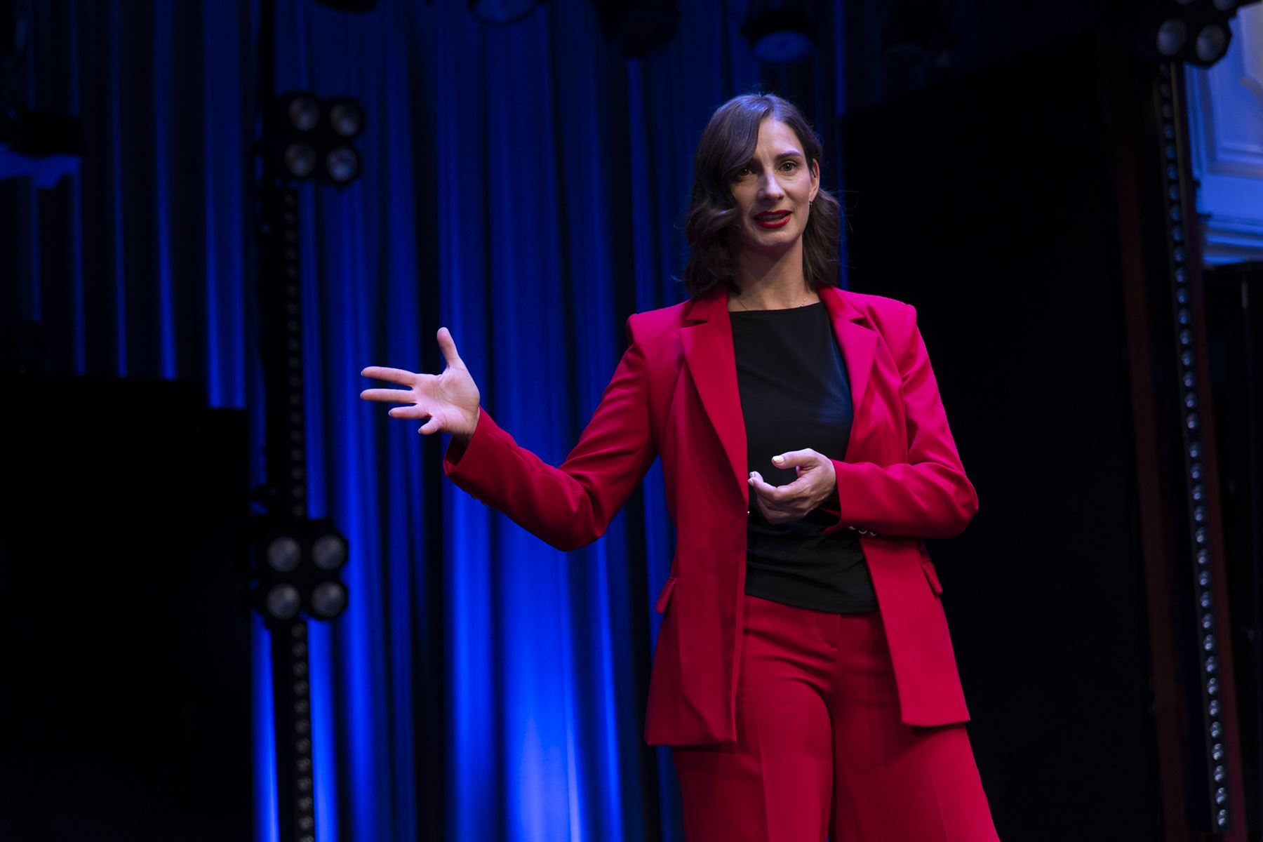 Eva Buttazoni im roten Anzug auf der Bühne der SpeakerNight Vienna